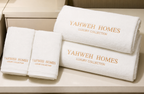 White towels with 'Yahweh Homes Luxury Collection' text on a wooden surface