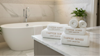 Bathroom setting with towels and bath products on a counter, featuring 'Yahweh Homes' branding.