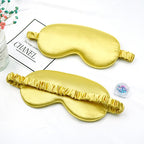 Two gold sleep masks on a white surface .