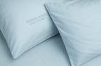 Two light blue pillows with 'YAHWEH HOMES' branding on a matching background