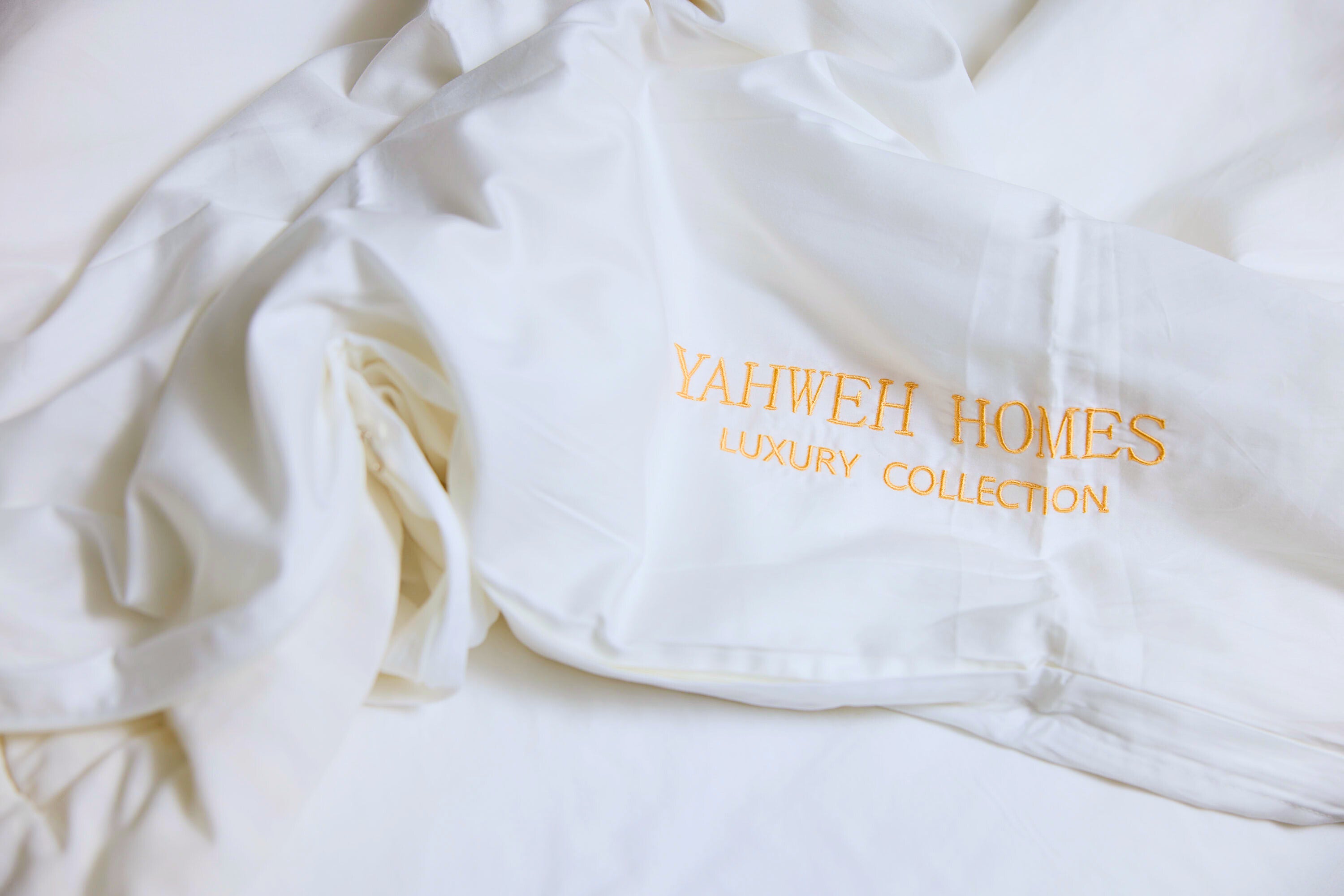 White Duvet cover with 'Yahweh Homes Luxury Collection' embroidery on a white background