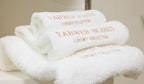 Stack of white towels with 'YAHWEH HOMES' branding.