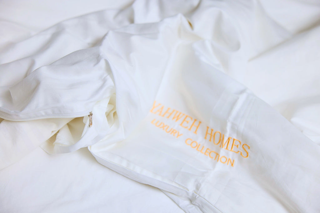 White Duvet cover with a zipper and  Yahweh Homes Luxury collection inscribed on it.