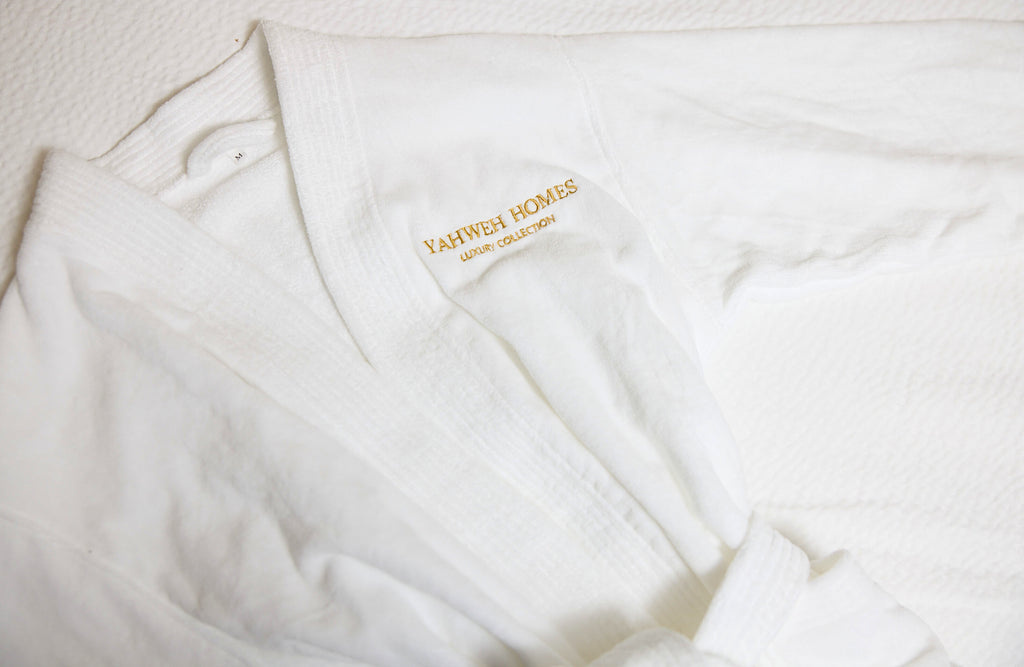 White robe with 'Yahweh Homes' branding on a light background
