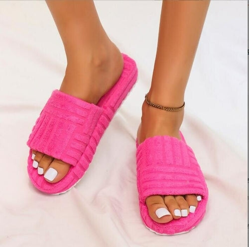 Pink slippers worn on feet with a white background