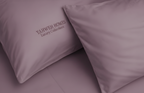 Two mauve pillows with 'Yahweh Homes Luxury Collections' branding on a matching background.