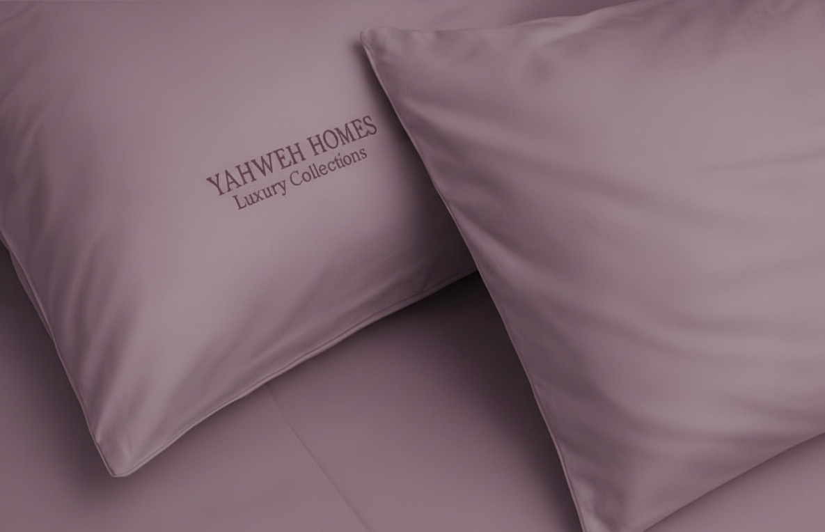 Two mauve pillows with 'Yahweh Homes Luxury Collections' branding on a matching background.