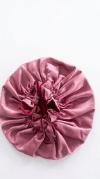 Pink satin hair Bonnet with a red interior on a white background