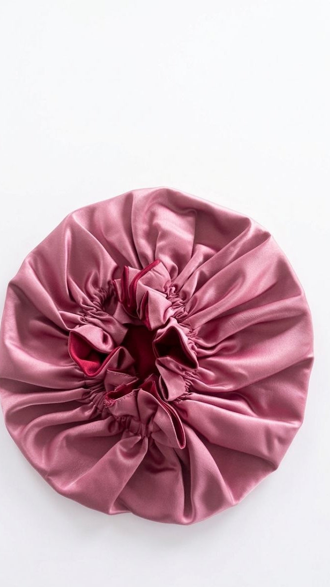 Pink satin hair Bonnet with a red interior on a white background