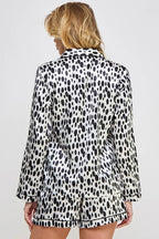 Person wearing a black and white polka dot outfit on a plain background