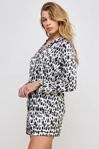 Woman wearing a black and white leopard print outfit on a plain background