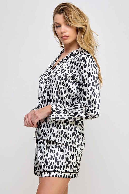 Woman wearing a black and white leopard print outfit on a plain background