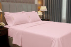 Pink bed sheets and pillows on a bed in a bedroom setting.