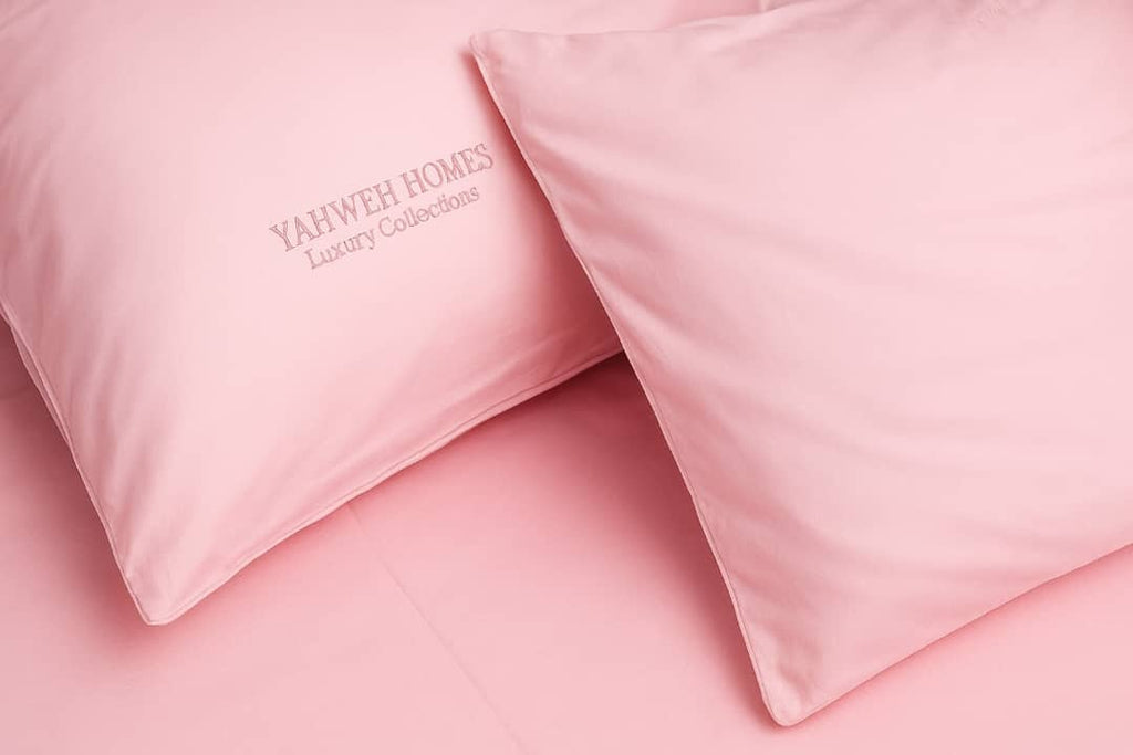 Pink pillows with 'YAHWEH HOMES' branding on a pink background